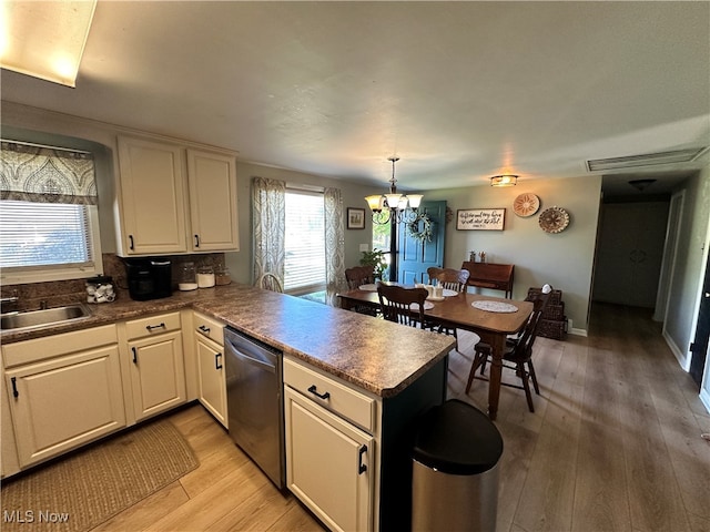 kitchen featuring hanging light fixtures, kitchen peninsula, dishwasher, and light hardwood / wood-style flooring