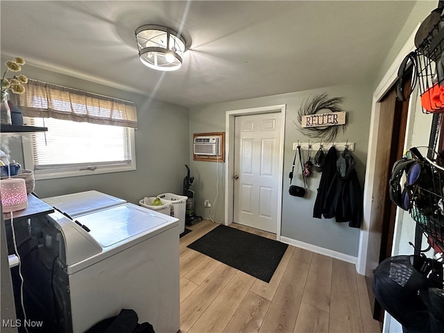 laundry area with separate washer and dryer, light wood-type flooring, and a wall mounted air conditioner