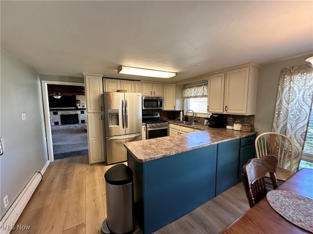 kitchen featuring kitchen peninsula, stainless steel appliances, light hardwood / wood-style flooring, sink, and a baseboard heating unit