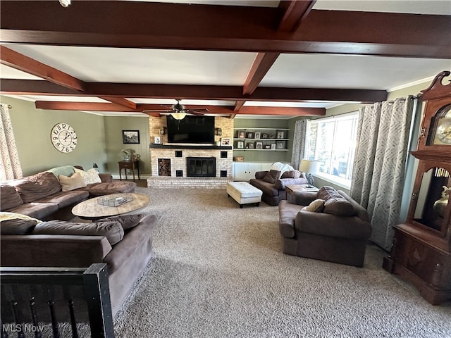 carpeted living room featuring a brick fireplace, beam ceiling, built in shelves, and ceiling fan