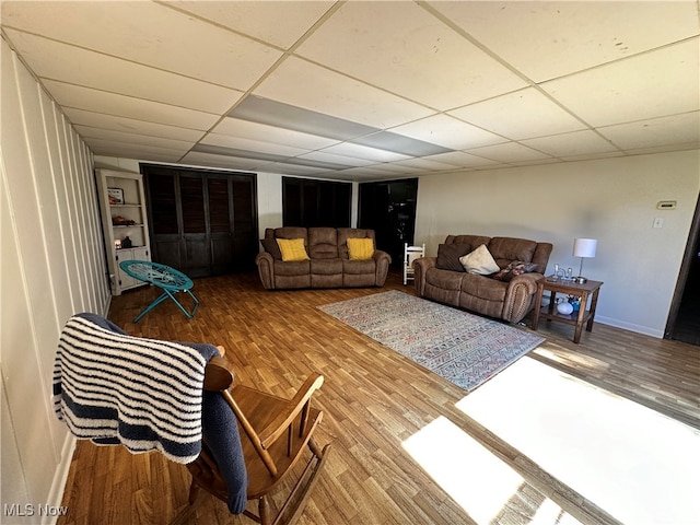 living room featuring hardwood / wood-style flooring and a paneled ceiling