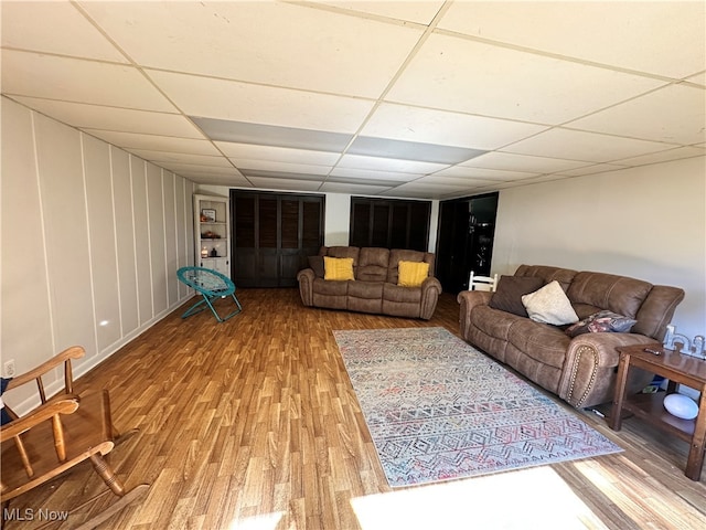 living room featuring a drop ceiling and hardwood / wood-style flooring