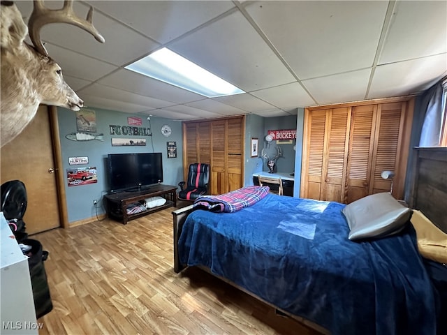 bedroom featuring a paneled ceiling and hardwood / wood-style floors