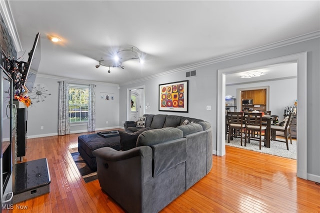 living room with crown molding and hardwood / wood-style floors