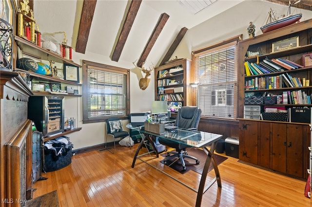 home office featuring light wood-type flooring, vaulted ceiling with beams, and plenty of natural light