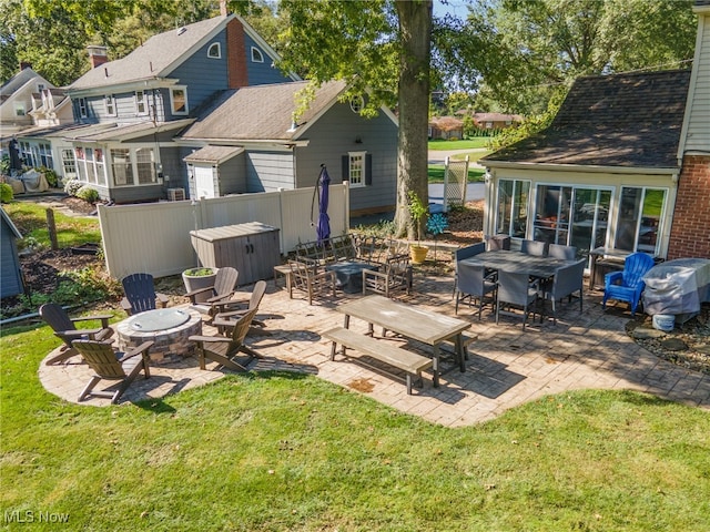 view of patio with a sunroom and an outdoor fire pit