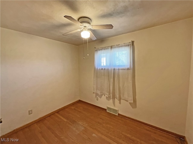 spare room with hardwood / wood-style floors and ceiling fan