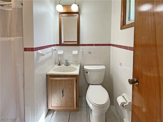 bathroom featuring tile walls, vanity, and toilet