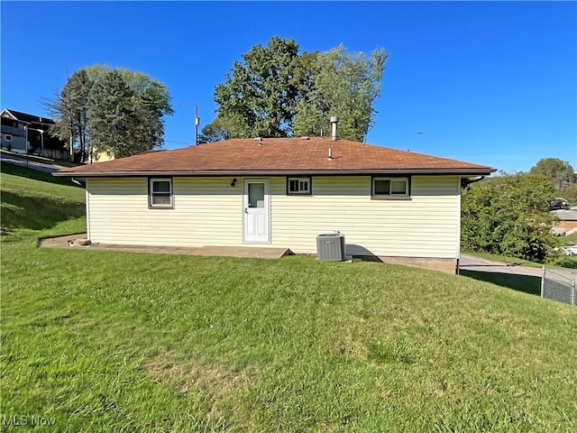 back of house with a lawn and central air condition unit