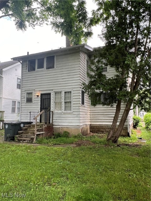 rear view of house featuring a yard