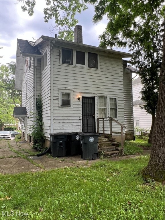 rear view of property featuring a yard