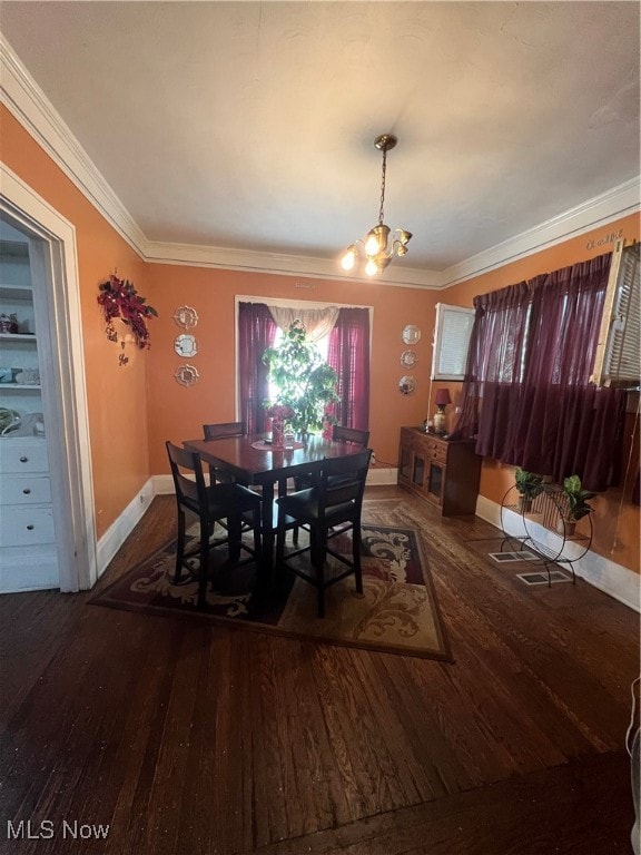 dining room featuring ornamental molding, a wealth of natural light, a notable chandelier, and dark hardwood / wood-style flooring