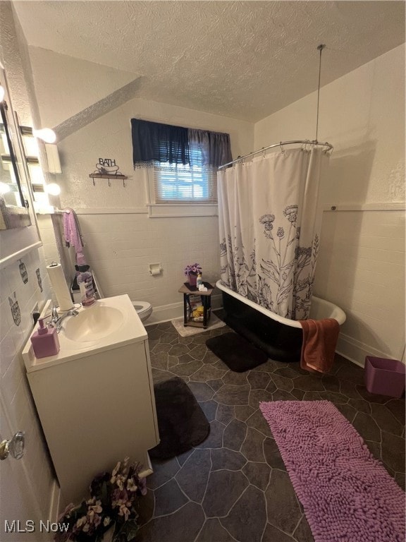 full bathroom with shower / bath combination with curtain, vanity, toilet, and a textured ceiling