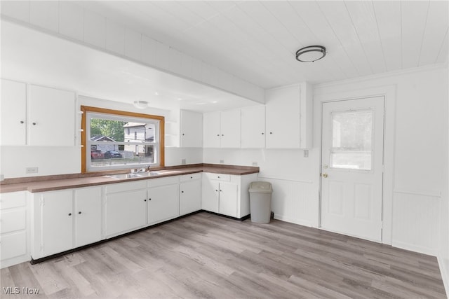 kitchen with white cabinets, sink, and light hardwood / wood-style floors