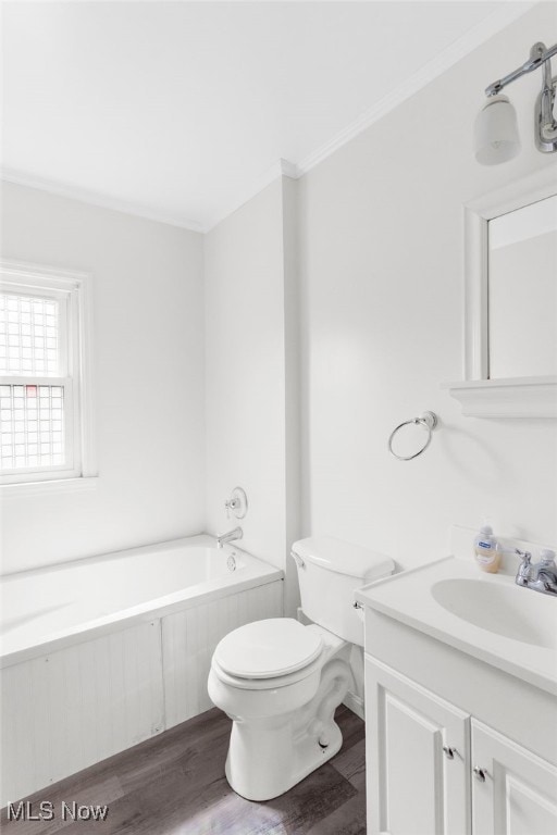 bathroom featuring vanity, toilet, a tub, ornamental molding, and hardwood / wood-style floors