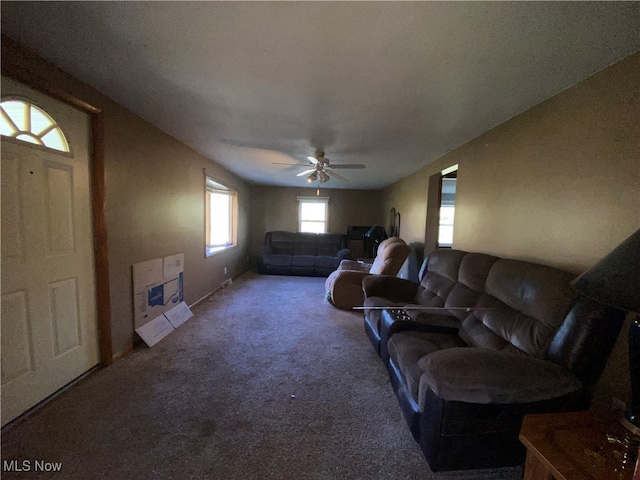 carpeted living room featuring ceiling fan and heating unit