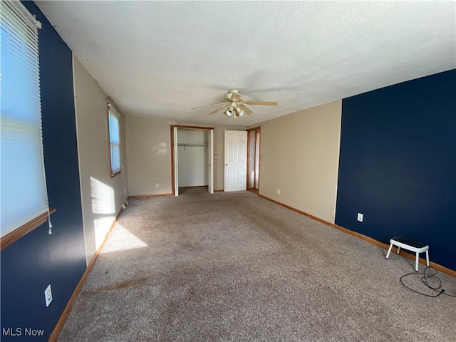 interior space with a textured ceiling and ceiling fan