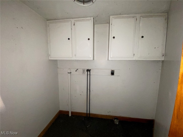 laundry area with hookup for an electric dryer and cabinets