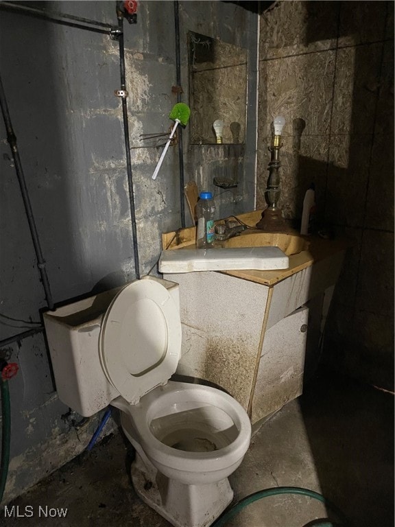 bathroom with concrete floors, sink, and toilet