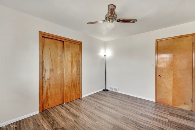 unfurnished bedroom featuring wood-type flooring, ceiling fan, and a closet