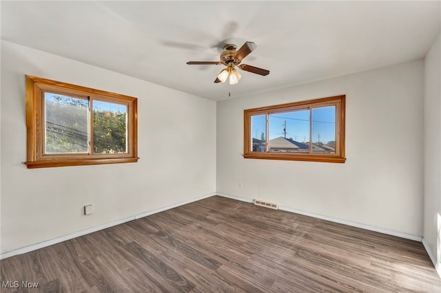 empty room featuring ceiling fan and dark hardwood / wood-style floors