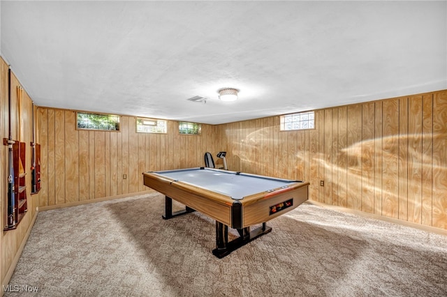 rec room with light carpet, plenty of natural light, and wood walls