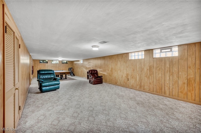 unfurnished room featuring a textured ceiling and wood walls