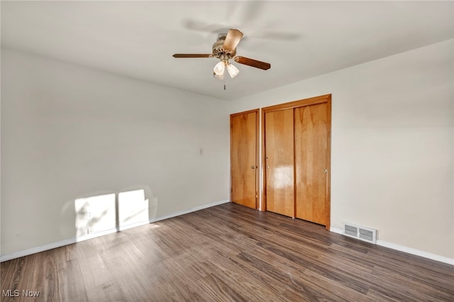 unfurnished bedroom featuring dark hardwood / wood-style flooring and ceiling fan