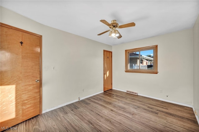 empty room featuring wood-type flooring and ceiling fan