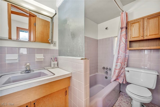 full bathroom with tile walls, tile patterned flooring, shower / bathtub combination with curtain, vanity, and toilet