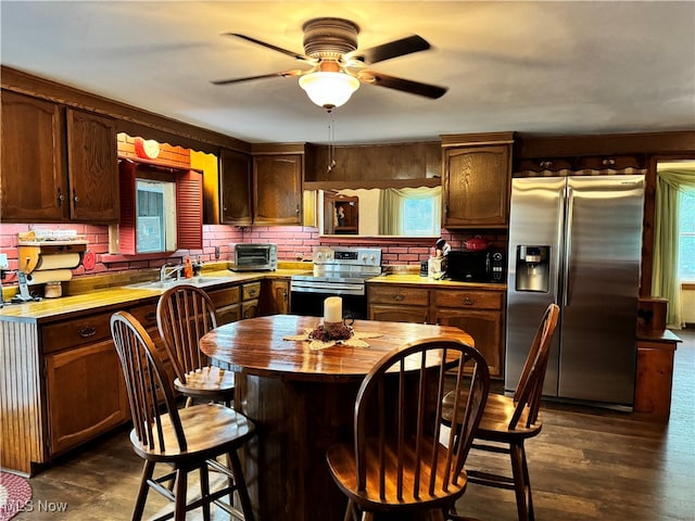 kitchen featuring appliances with stainless steel finishes, tasteful backsplash, ceiling fan, dark hardwood / wood-style floors, and sink