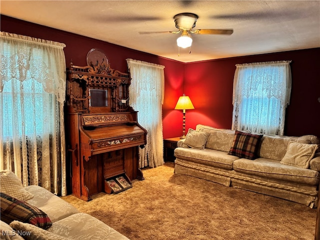 living room featuring ceiling fan, crown molding, carpet flooring, and a textured ceiling