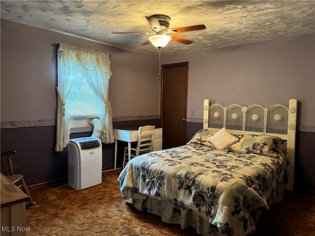 carpeted bedroom featuring a textured ceiling and ceiling fan