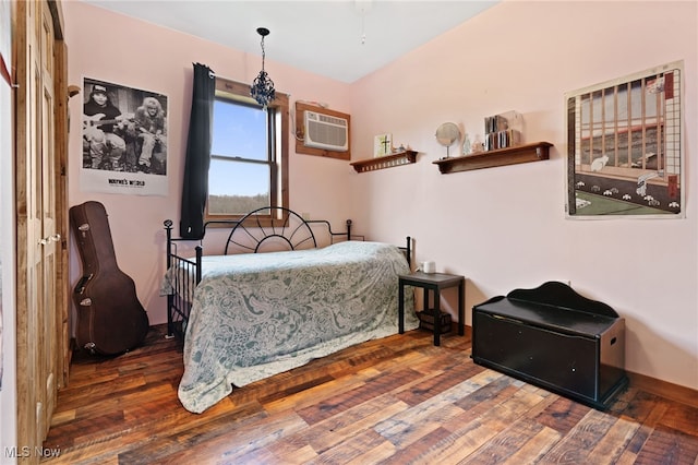 bedroom featuring dark wood-type flooring and a wall mounted AC