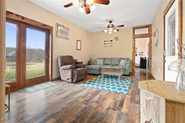 living room featuring wood-type flooring, an AC wall unit, and ceiling fan