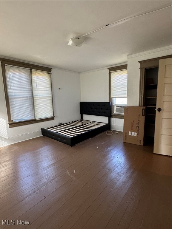 unfurnished bedroom featuring dark wood-type flooring and cooling unit