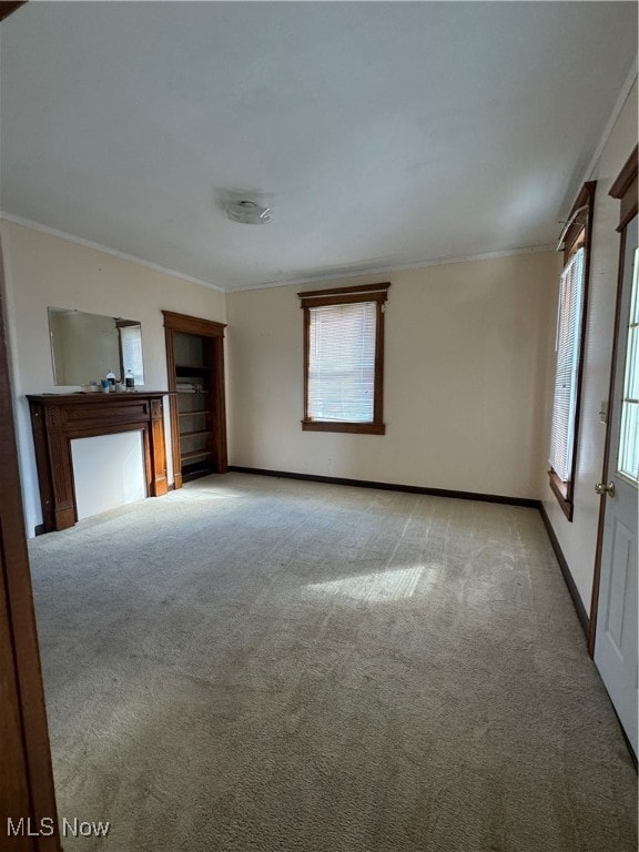 unfurnished living room featuring ornamental molding and light carpet