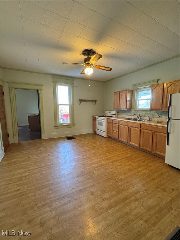 kitchen featuring white appliances, a healthy amount of sunlight, and light hardwood / wood-style flooring