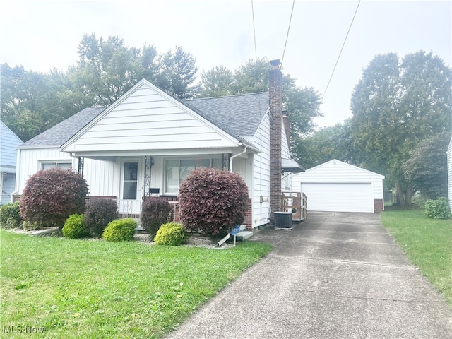 bungalow-style home featuring cooling unit, a front yard, an outbuilding, and a garage