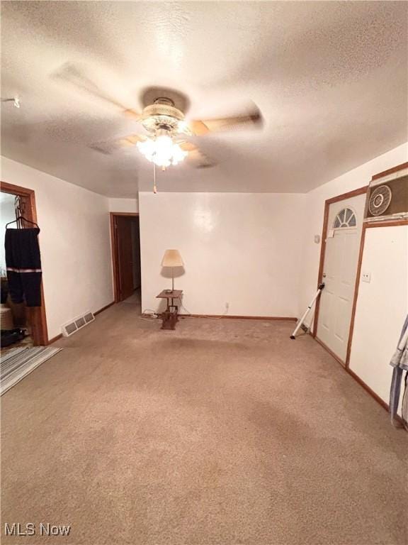 basement featuring ceiling fan, carpet flooring, and a textured ceiling