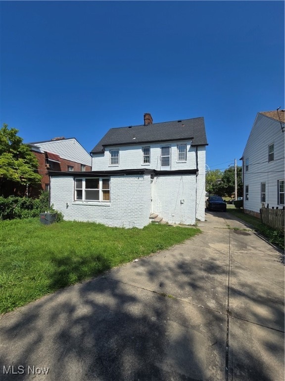 back of house with a lawn