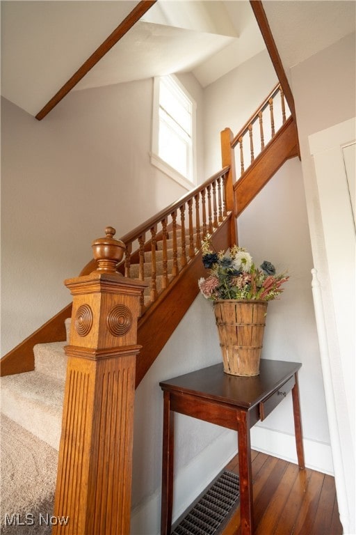 stairs with lofted ceiling and hardwood / wood-style floors