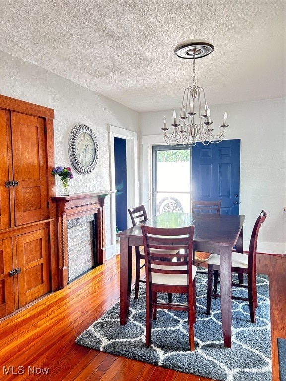 dining room featuring a textured ceiling, hardwood / wood-style floors, and a chandelier