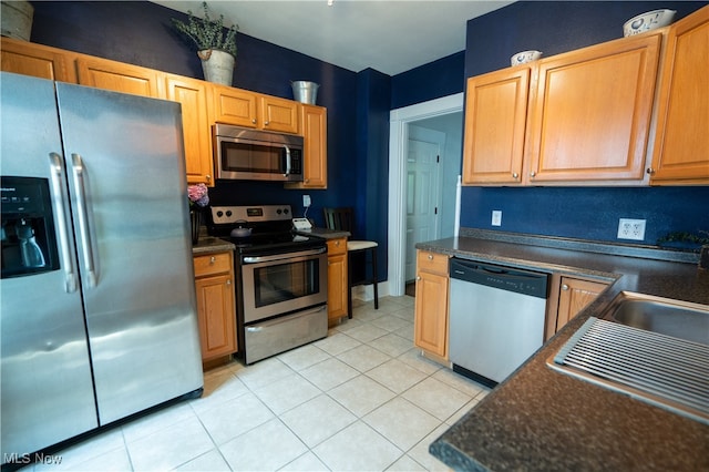 kitchen with appliances with stainless steel finishes and light tile patterned floors