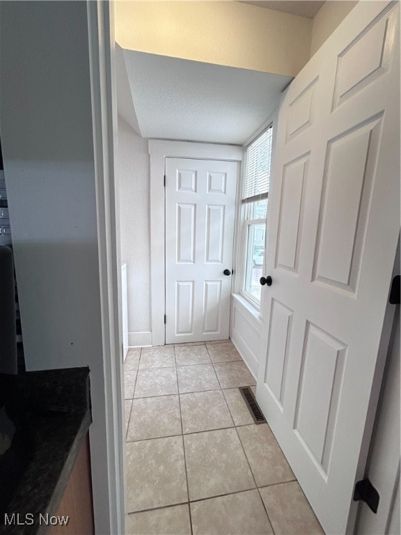 bathroom featuring tile patterned flooring and a textured ceiling