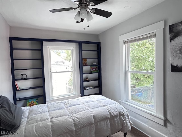 bedroom featuring ceiling fan, carpet, and multiple windows