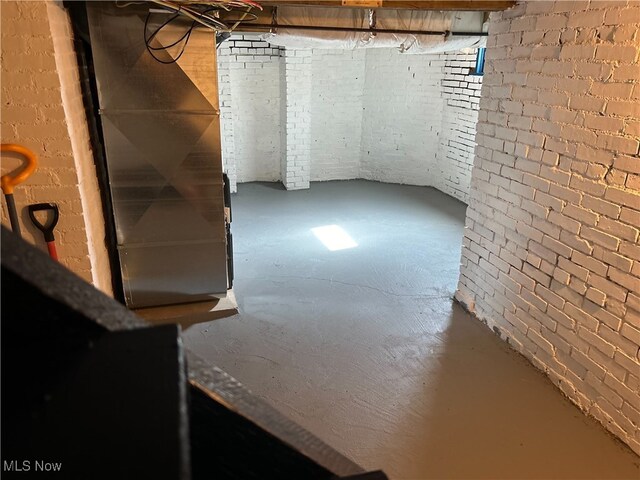 basement with brick wall and heating unit