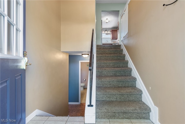 stairs featuring tile patterned flooring