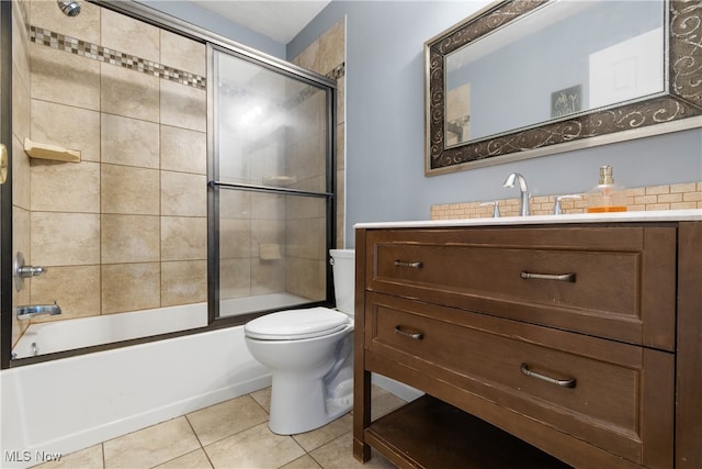 full bathroom featuring tile patterned floors, shower / bath combination with glass door, vanity, and toilet