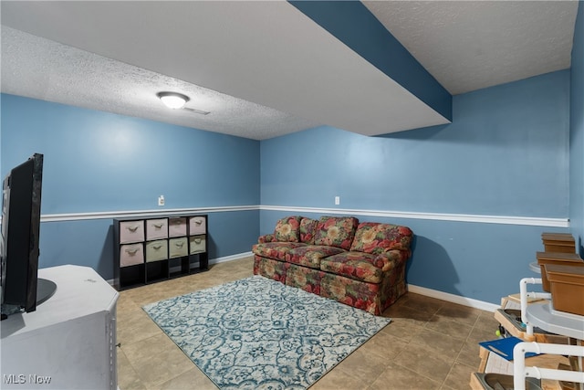 living area featuring a textured ceiling and tile patterned floors